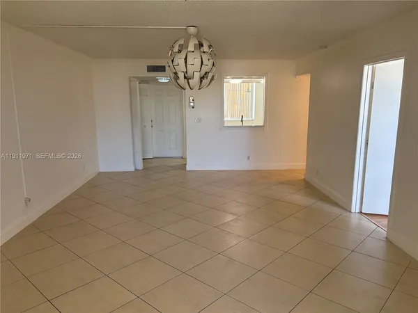 an empty room with kitchen view