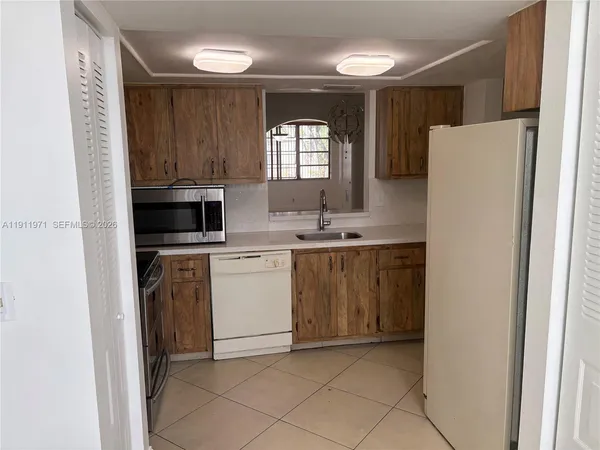 a kitchen with a sink a stove and cabinets