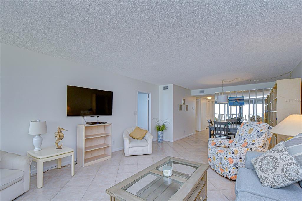 7100 Sunset Way, Unit 505 St. Pete Beach, FL 33706 - Photo 11 of 28 a living room with furniture and a flat screen tv