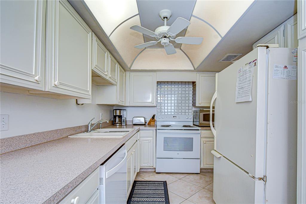 7100 Sunset Way, Unit 505 St. Pete Beach, FL 33706 - Photo 12 of 28 a kitchen with a sink cabinets and stainless steel appliances