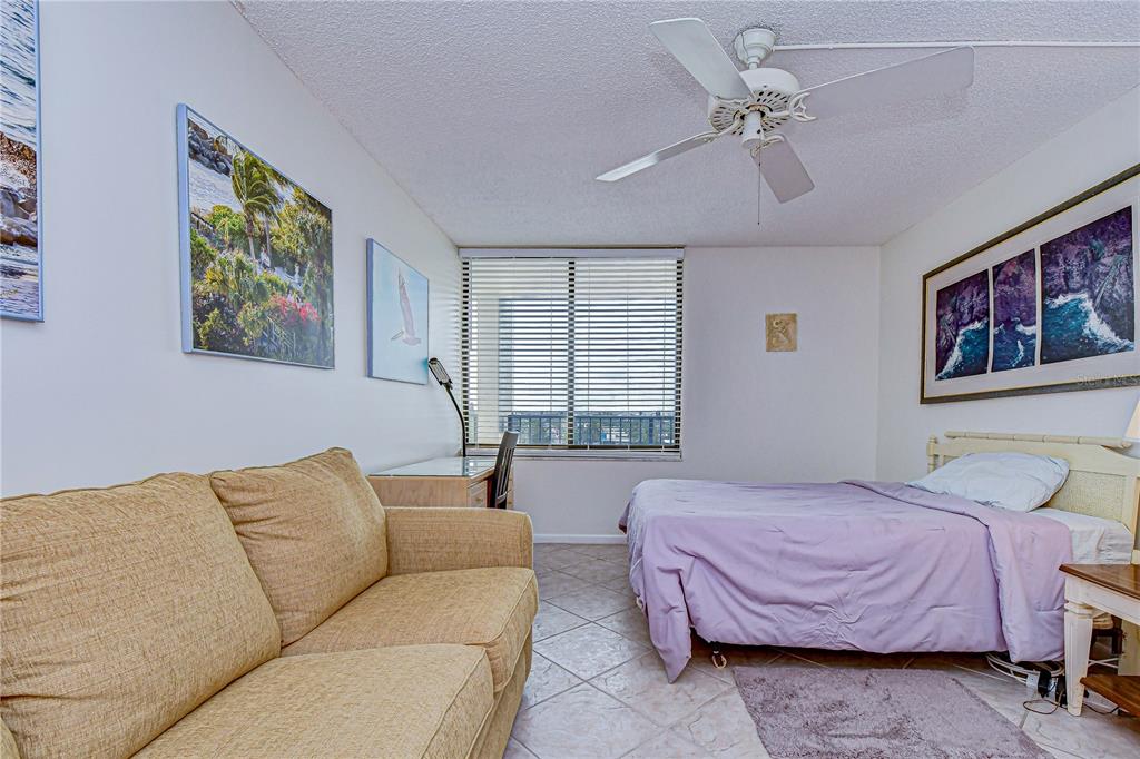 7100 Sunset Way, Unit 505 St. Pete Beach, FL 33706 - Photo 14 of 28 a bedroom with a bed couch and window