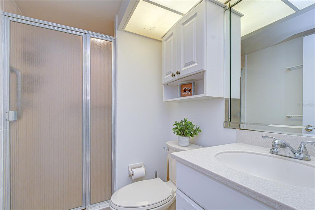 7100 Sunset Way, Unit 505 St. Pete Beach, FL 33706 - Photo 16 of 28 a bathroom with a sink vanity mirror and toilet