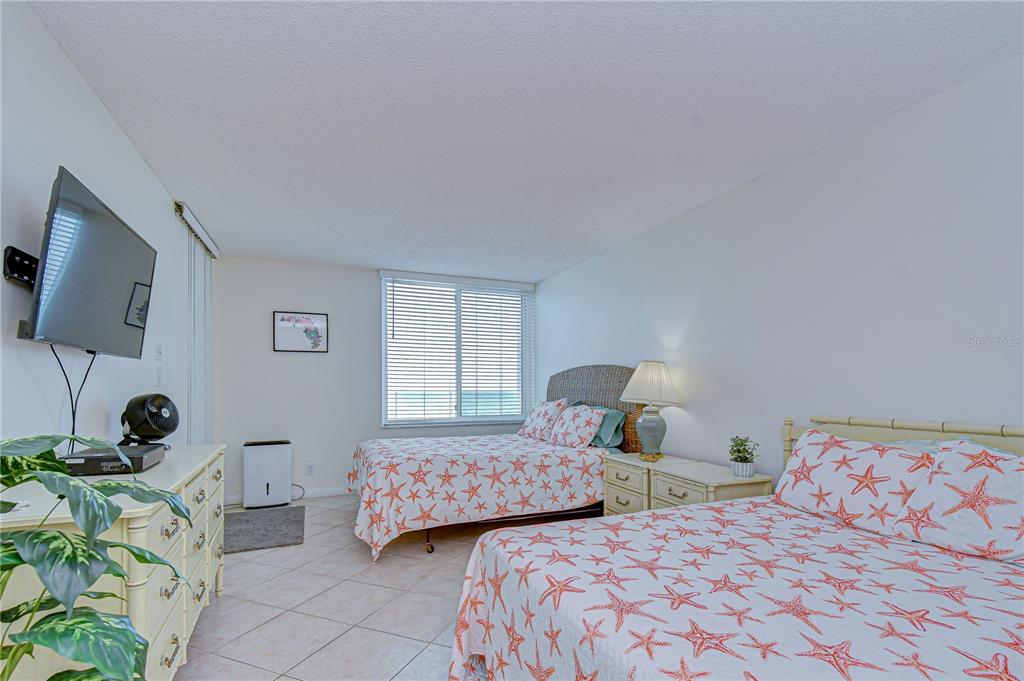 7100 Sunset Way, Unit 505 St. Pete Beach, FL 33706 - Photo 17 of 28 a bedroom with two beds and a flat screen tv