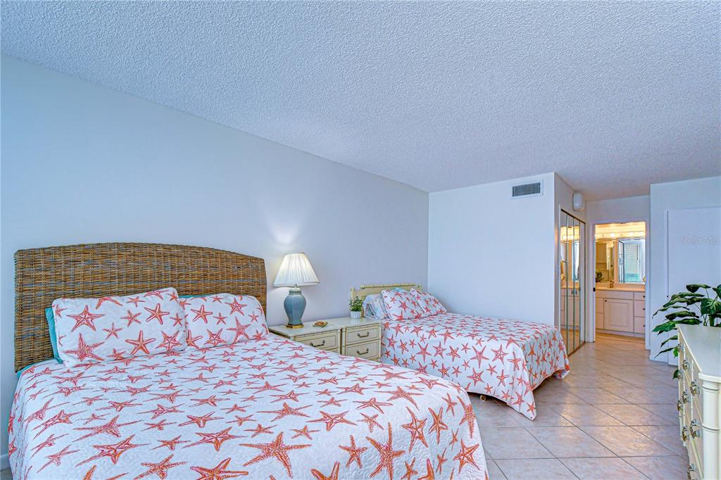 7100 Sunset Way, Unit 505 St. Pete Beach, FL 33706 - Photo 18 of 28 a bedroom with two beds and potted plant