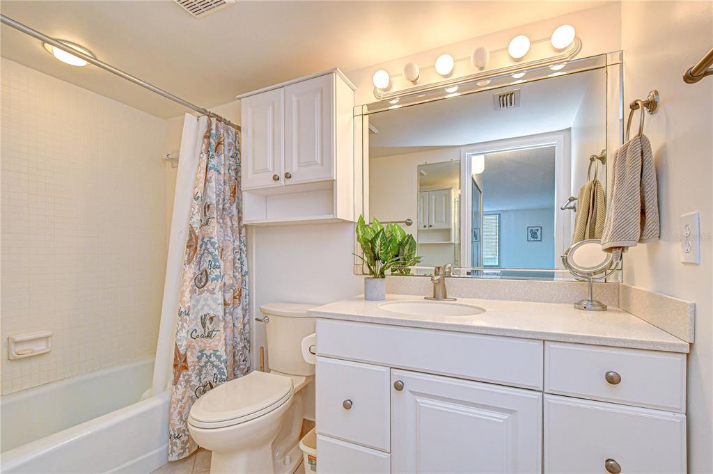 7100 Sunset Way, Unit 505 St. Pete Beach, FL 33706 - Photo 20 of 28 a bathroom with a sink toilet a mirror a vanity and shower