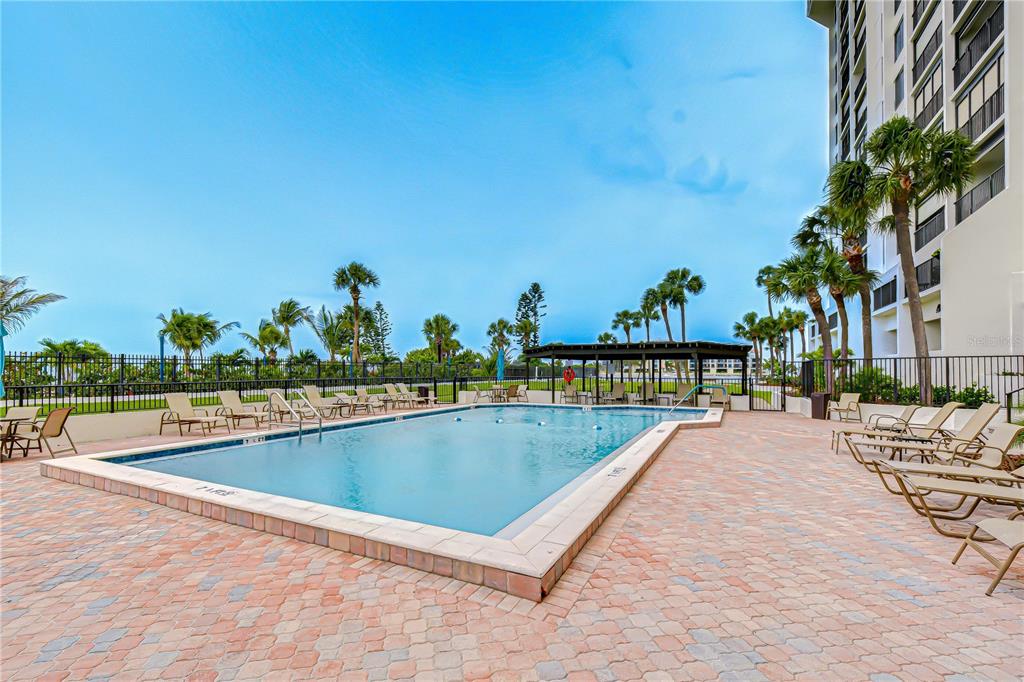 7100 Sunset Way, Unit 505 St. Pete Beach, FL 33706 - Photo 25 of 28 a view of swimming pool with outdoor seating and plants