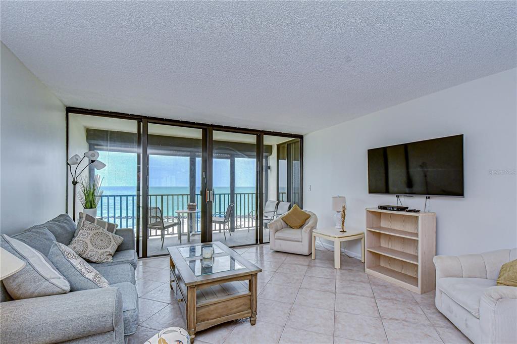 7100 Sunset Way, Unit 505 St. Pete Beach, FL 33706 - Photo 6 of 28 a living room with furniture and a flat screen tv