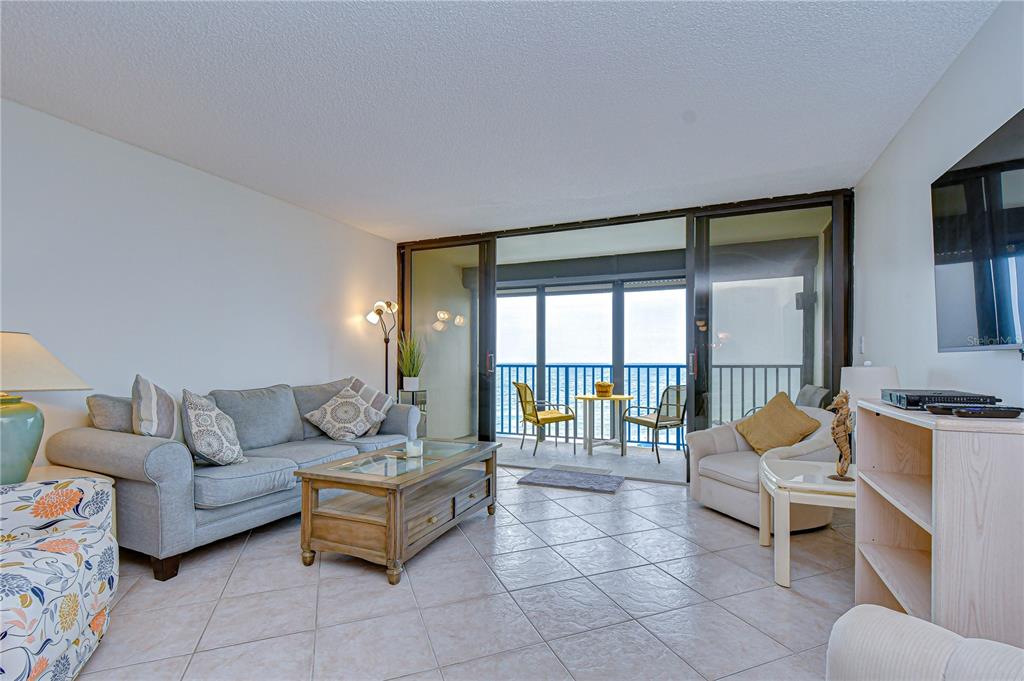 7100 Sunset Way, Unit 505 St. Pete Beach, FL 33706 - Photo 7 of 28 a living room with furniture and a floor to ceiling window