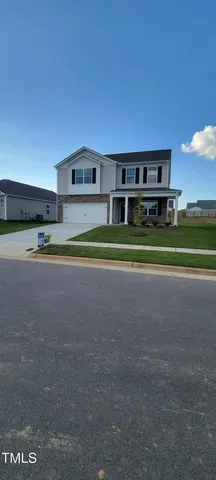 a front view of a house with a garden and yard