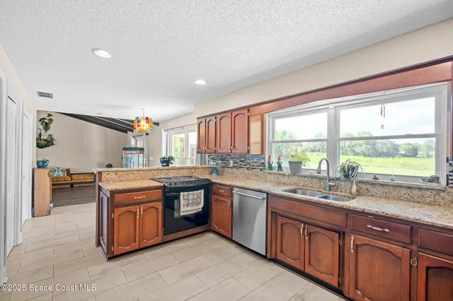 a kitchen with granite countertop a sink and a window