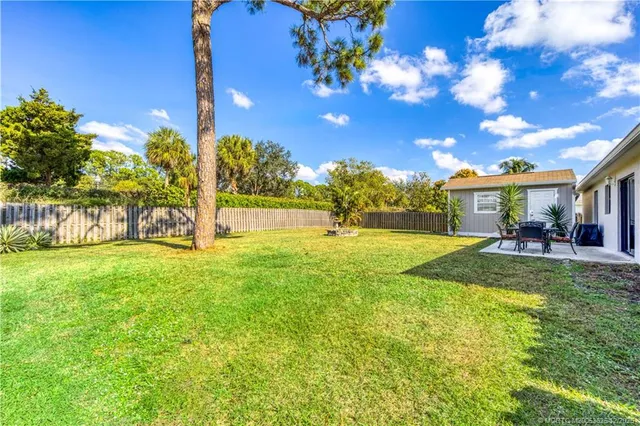 a view of a house with backyard and a tree