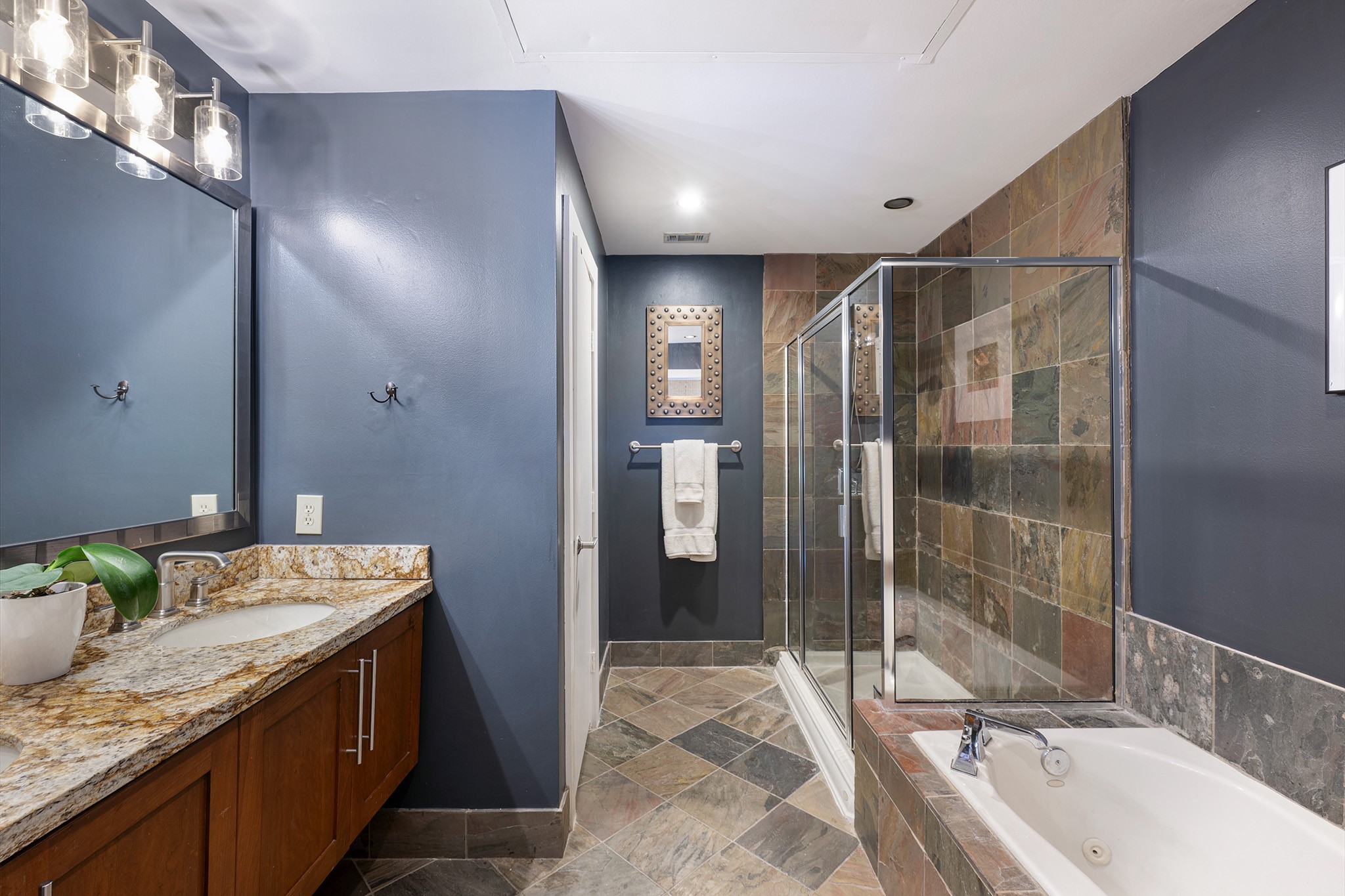 1722 Washington Avenue, Unit D Houston, TX 77007 - Photo 20 of 28 Luxurious primary bathroom offers double sinks, granite counter, jetted tub and walk-in shower.