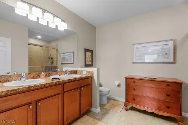 a bathroom with a double vanity sink mirror and toilet