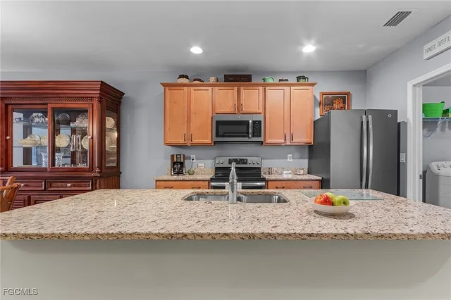 a kitchen with granite countertop a refrigerator and a stove top oven