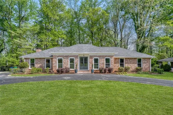a front view of a house with a yard and trees