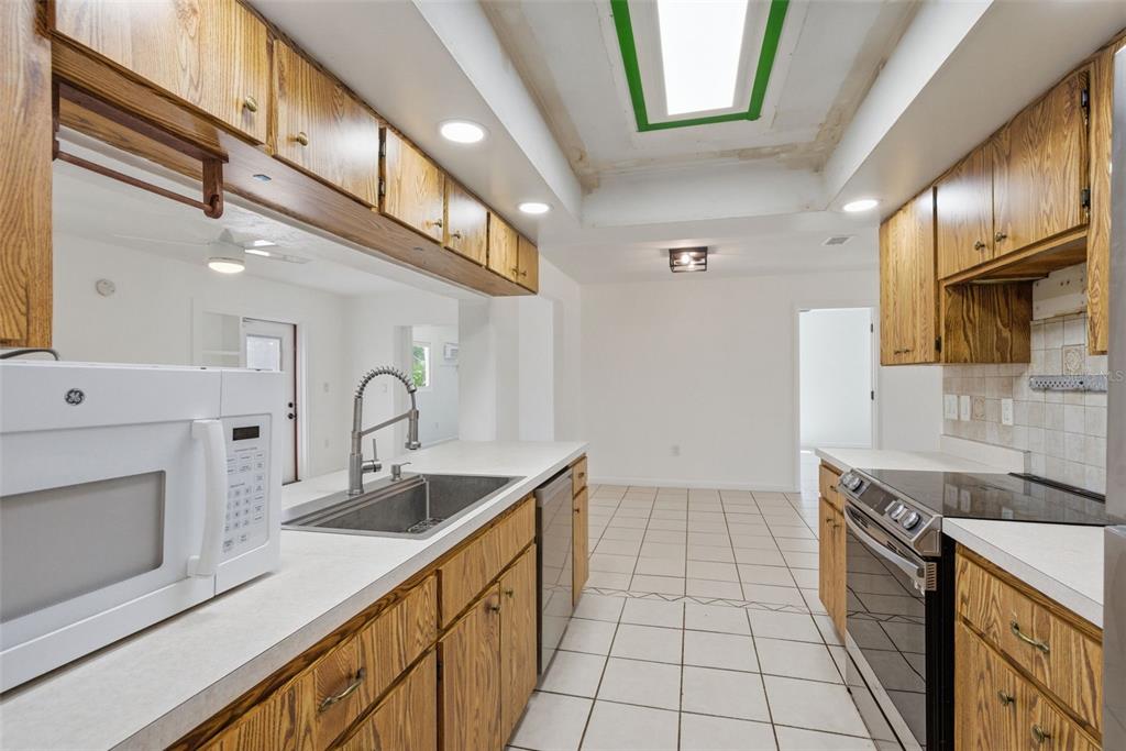 4536 Webber Street Sarasota, FL 34232 - Photo 11 of 45 a kitchen with granite countertop a sink a stove and cabinets