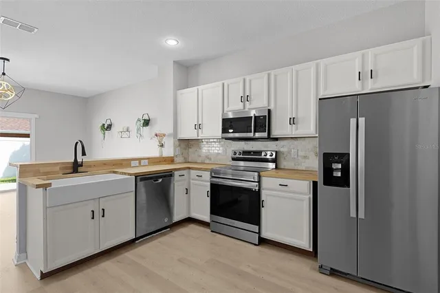 a kitchen with stainless steel appliances a sink cabinets and a refrigerator