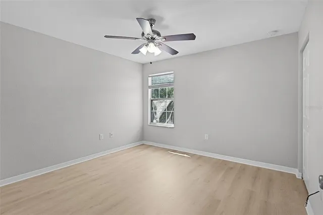 an empty room with a window and a fan