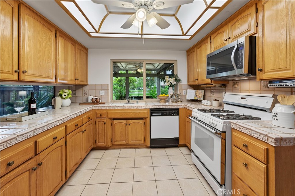 513 Pebble Beach Place Fullerton, CA 92835 - Photo 13 of 42 a kitchen with stainless steel appliances granite countertop a stove a sink and a microwave