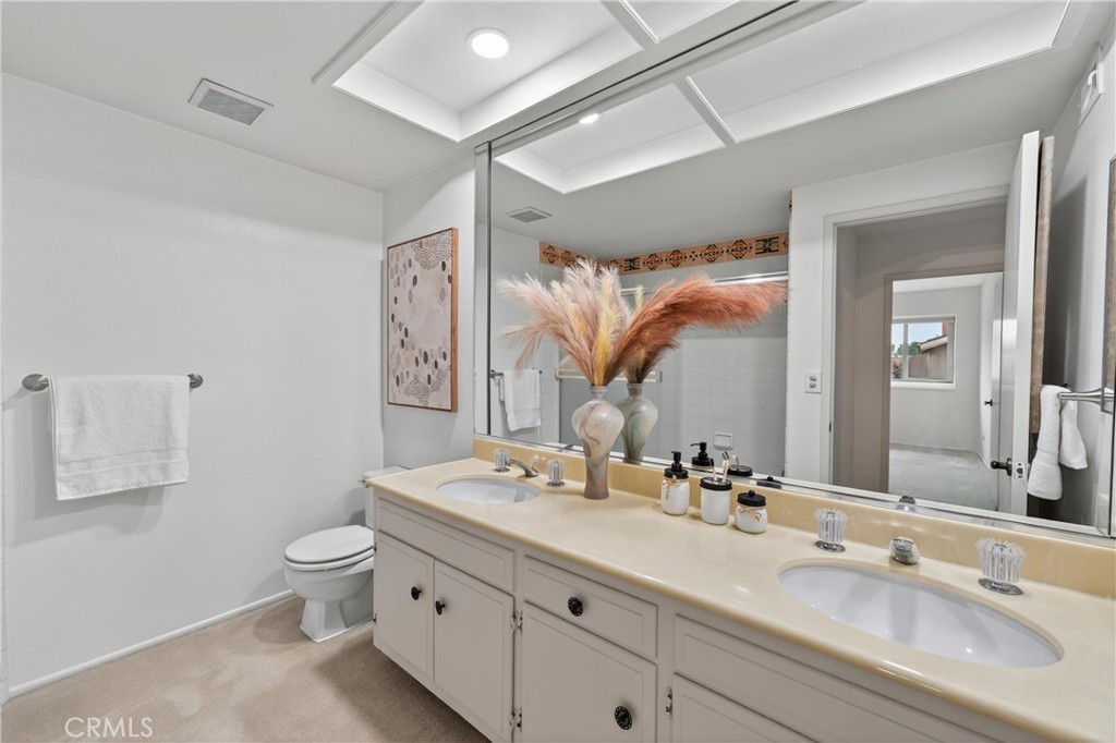 513 Pebble Beach Place Fullerton, CA 92835 - Photo 22 of 42 a bathroom with a double vanity sink toilet and a mirror