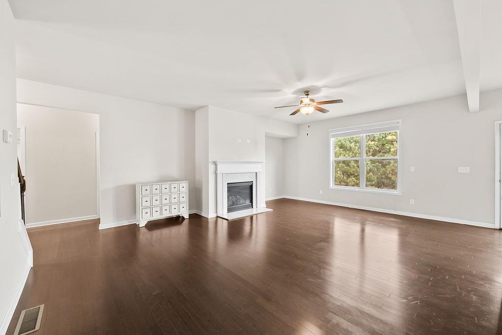 2415 Matlin Way Buford, GA 30519 - Photo 11 of 66 an empty room with wooden floor fireplace and windows