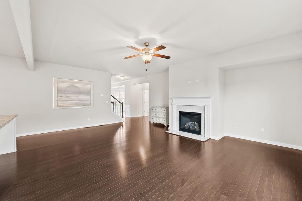 2415 Matlin Way Buford, GA 30519 - Photo 13 of 66 a view of a room with chandelier fan and wooden floor