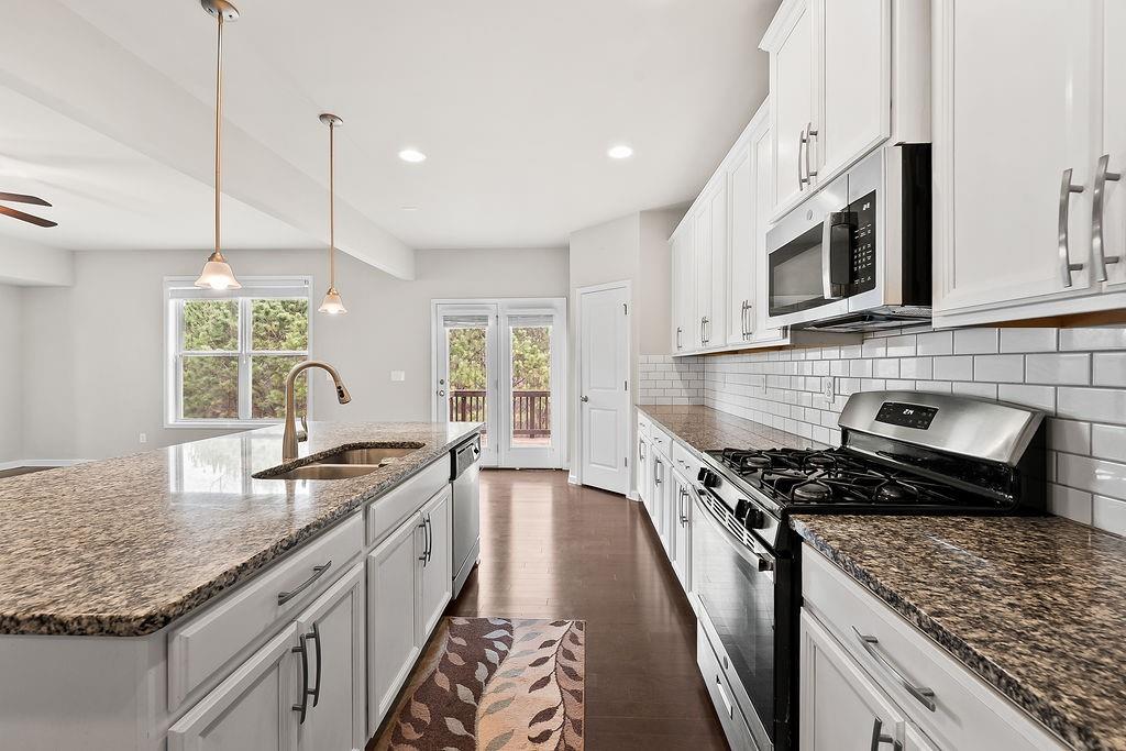 2415 Matlin Way Buford, GA 30519 - Photo 17 of 66 a kitchen with stainless steel appliances granite countertop a stove a sink and a microwave