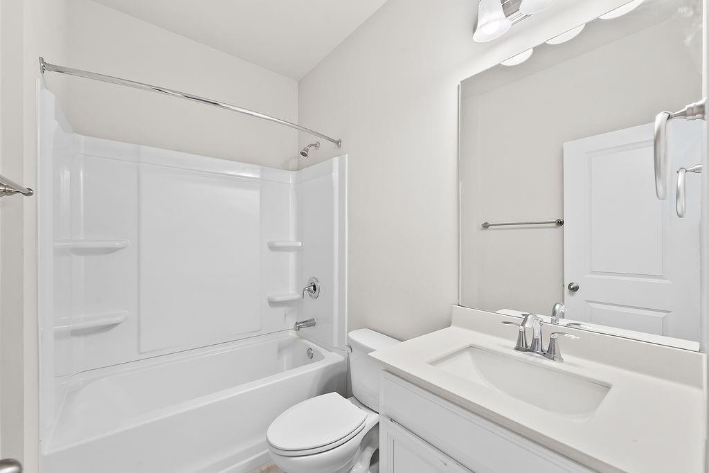 2415 Matlin Way Buford, GA 30519 - Photo 22 of 66 a bathroom with a bathtub shower sink vanity mirror and toilet