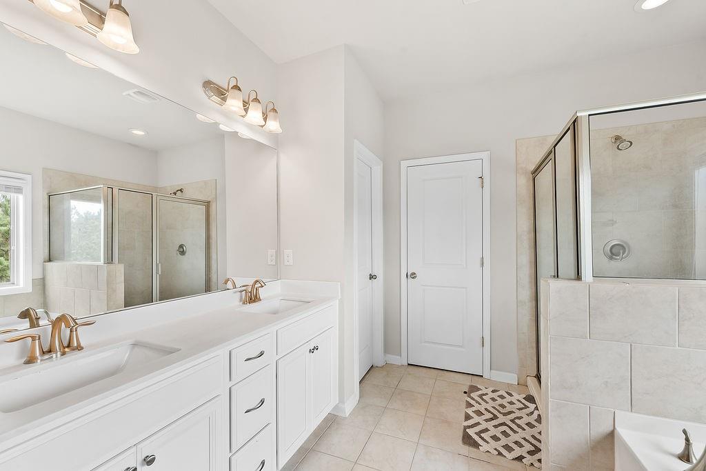 2415 Matlin Way Buford, GA 30519 - Photo 29 of 66 a spacious bathroom with a double vanity sink mirror and double