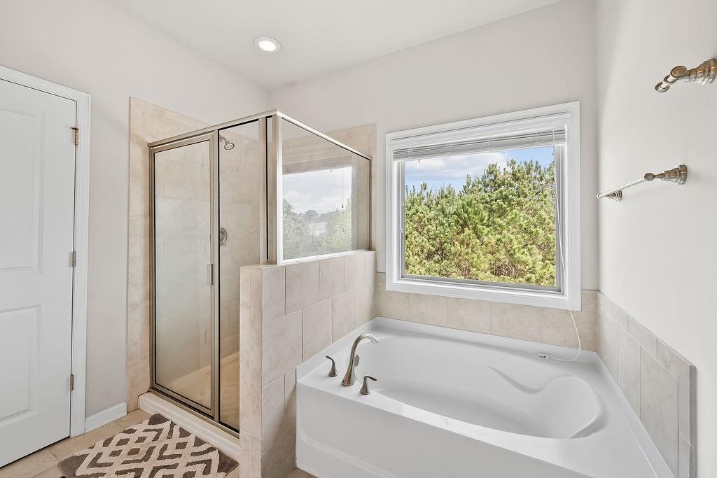 2415 Matlin Way Buford, GA 30519 - Photo 30 of 66 a bathroom with a bathtub and a shower