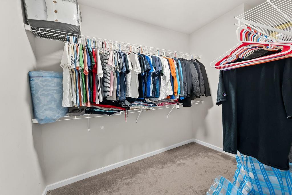 2415 Matlin Way Buford, GA 30519 - Photo 31 of 66 a view of walk in closet with clothes and shoes