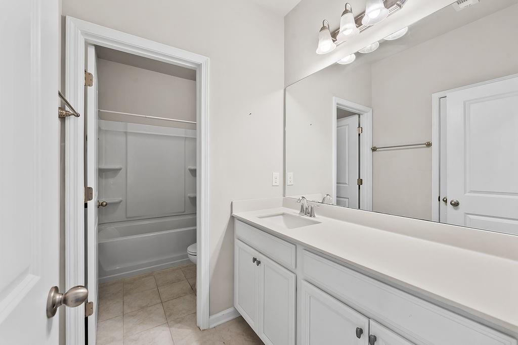 2415 Matlin Way Buford, GA 30519 - Photo 41 of 66 a bathroom with a double vanity sink a mirror and a shower