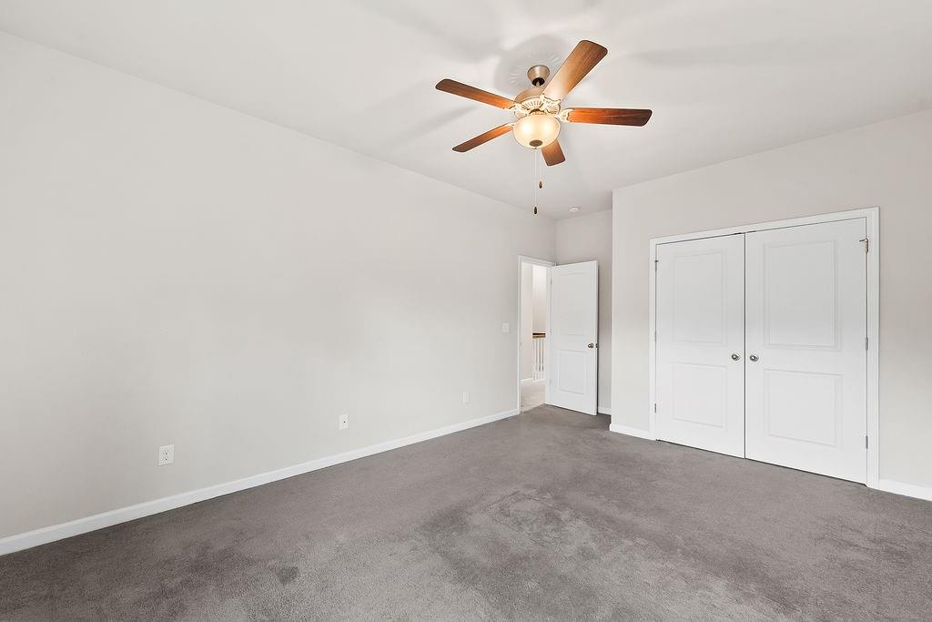 2415 Matlin Way Buford, GA 30519 - Photo 44 of 66 an empty room with closet and fan