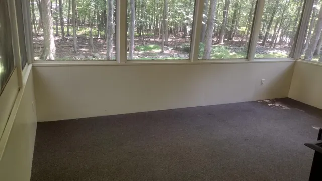 an empty room with wooden floor and a window