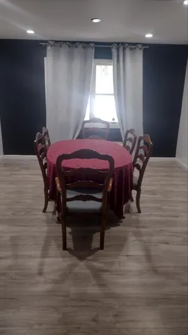 a view of a white house with large trees and outdoor space