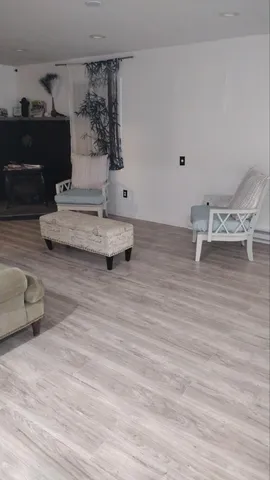 a view of an empty room with wooden floor and closet area