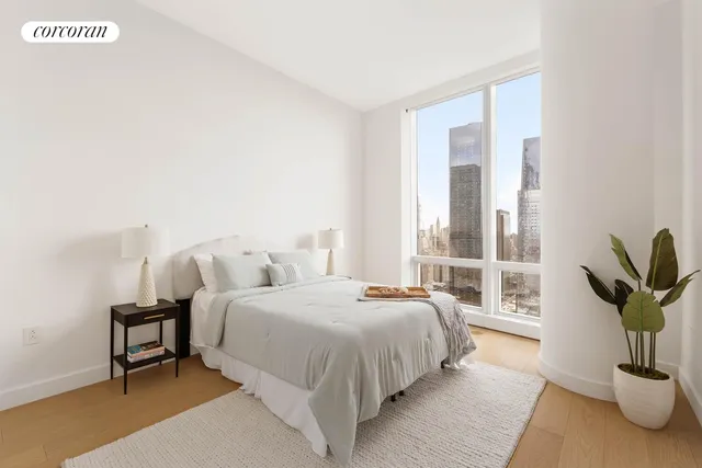 a bedroom with a large bed and a potted plant