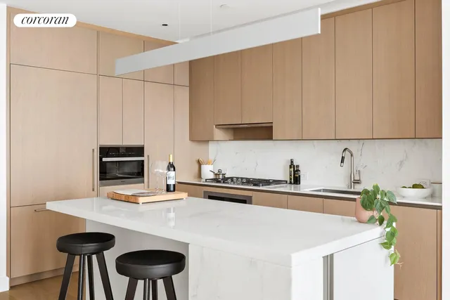 a kitchen with stainless steel appliances a stove a sink a refrigerator a counter space and cabinets