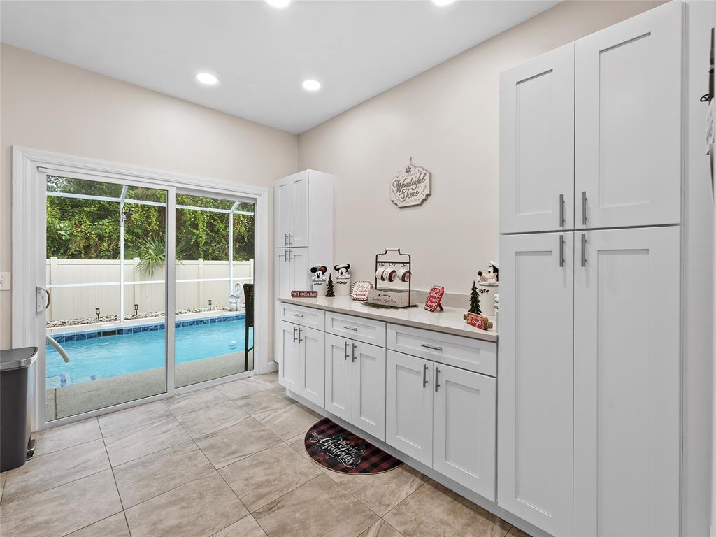 4480 23rd Way Vero Beach, FL 32966 - Photo 11 of 29 a large white kitchen with a sink and cabinets