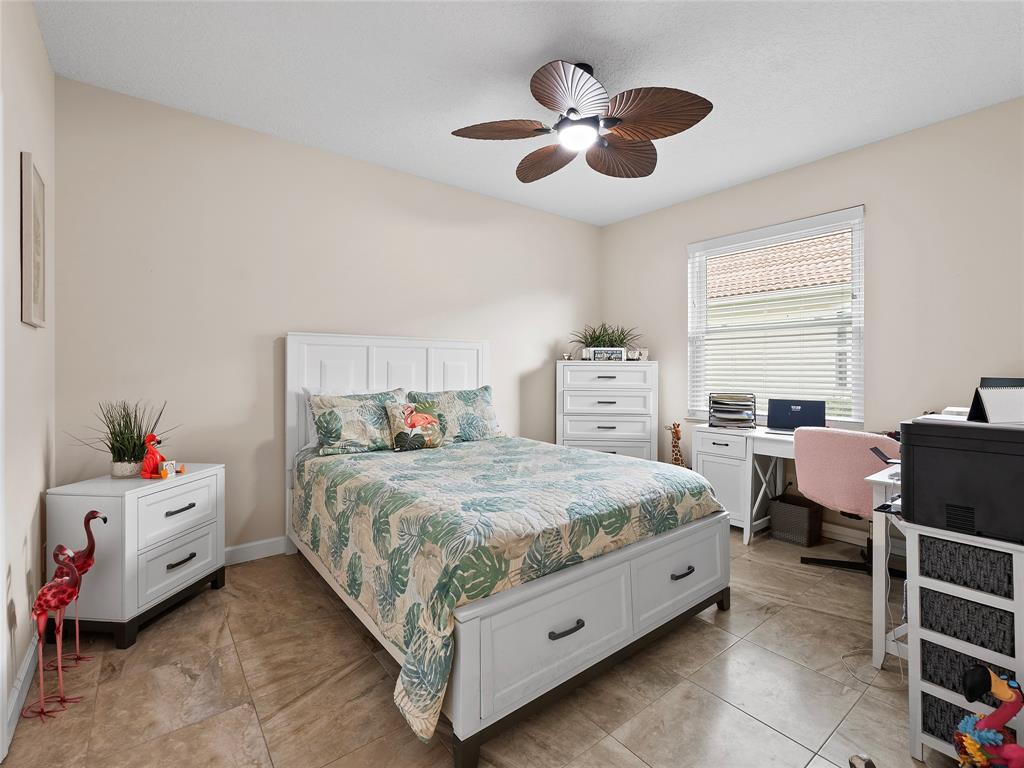 4480 23rd Way Vero Beach, FL 32966 - Photo 14 of 29 a bedroom with a bed and a chandelier