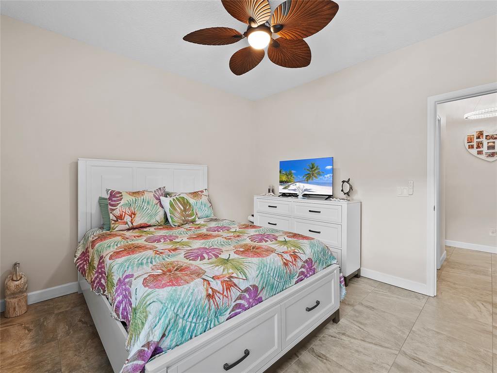 4480 23rd Way Vero Beach, FL 32966 - Photo 17 of 29 a bedroom with a bed and a chandelier