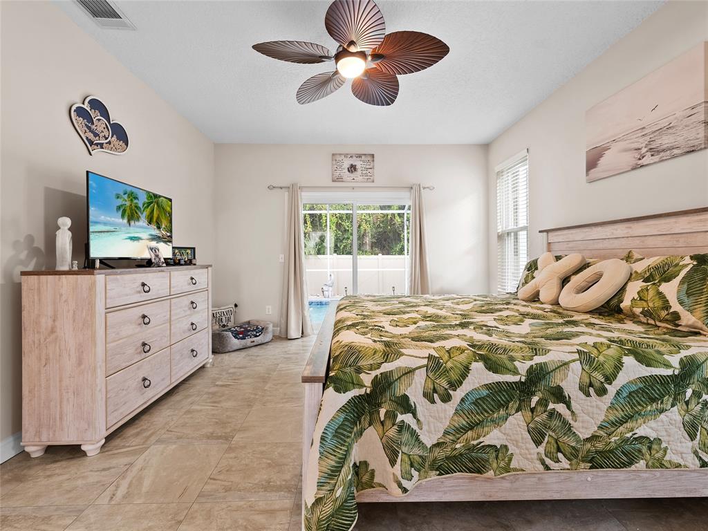 4480 23rd Way Vero Beach, FL 32966 - Photo 23 of 29 a bedroom with a bed and a flat tv screen on dresser