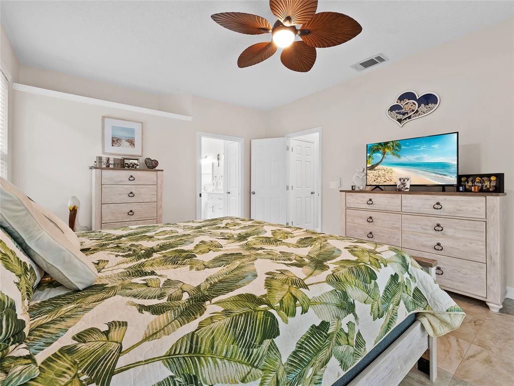 4480 23rd Way Vero Beach, FL 32966 - Photo 24 of 29 a bedroom with a bed and a flat screen tv