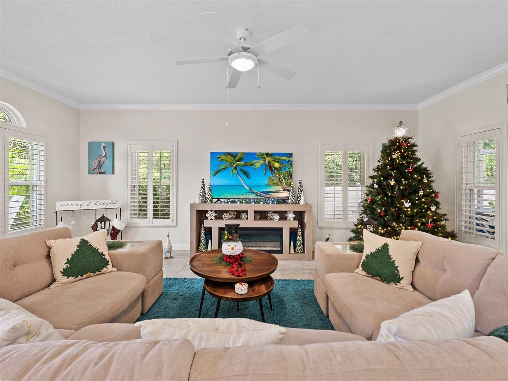 4480 23rd Way Vero Beach, FL 32966 - Photo 4 of 29 a living room with furniture a fireplace and a flat screen tv