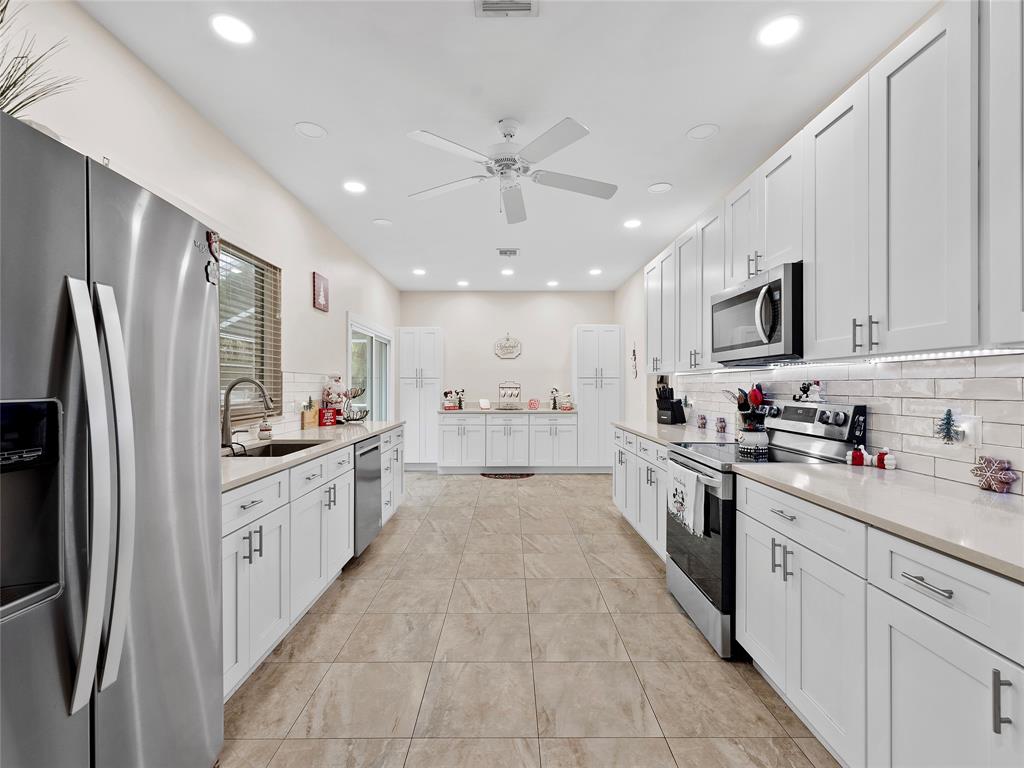 4480 23rd Way Vero Beach, FL 32966 - Photo 8 of 29 a large kitchen with stainless steel appliances lots of counter space and wooden floors