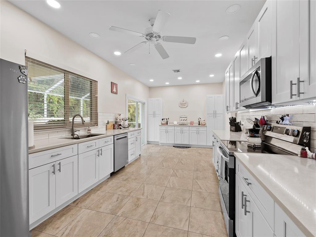 4480 23rd Way Vero Beach, FL 32966 - Photo 9 of 29 a kitchen with stainless steel appliances granite countertop a sink and cabinets