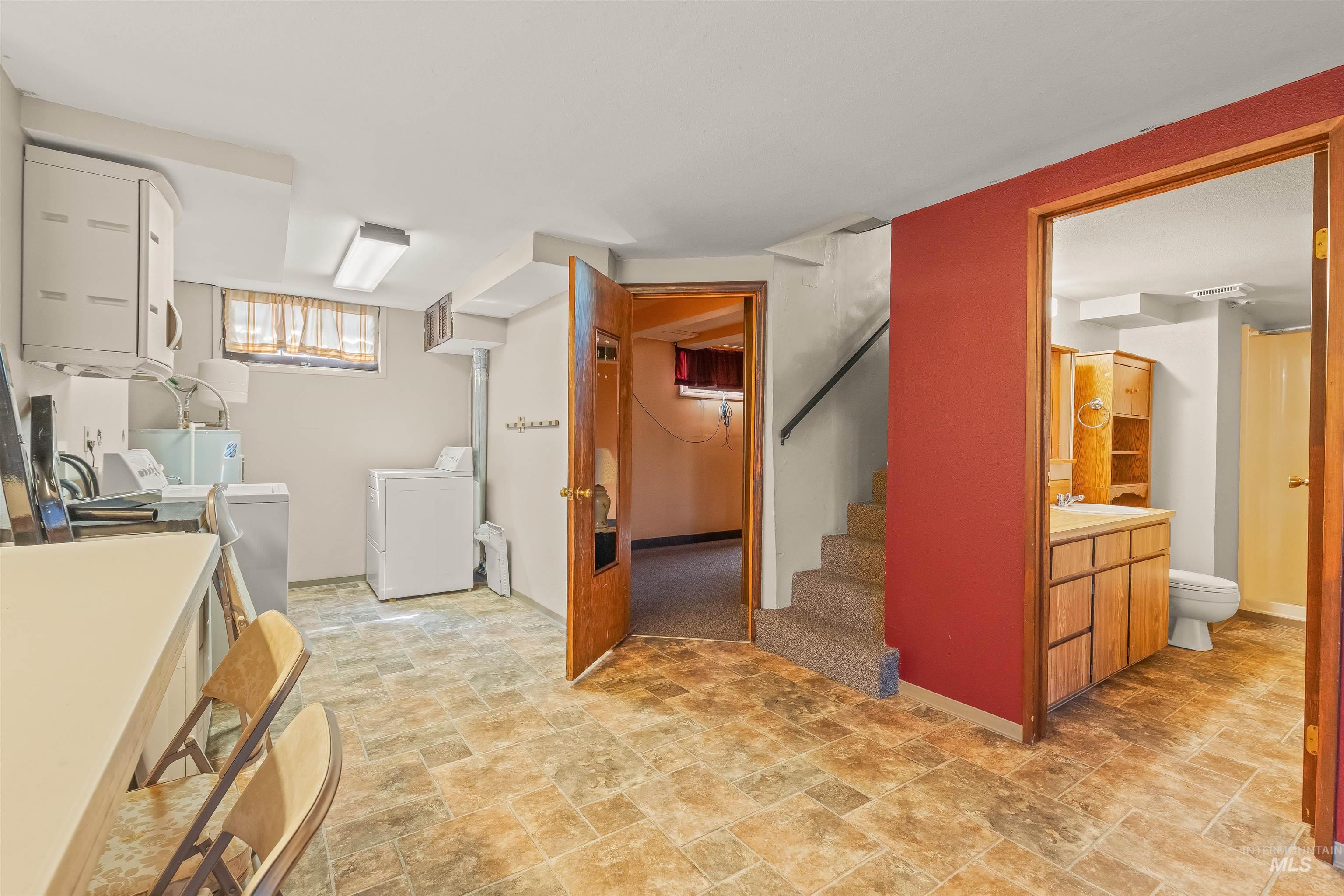 1663 9th Avenue Lewiston, ID 83501 - Photo 20 of 36 Basement utility area featuring tiled flooring, a built-in countertop, overhead cabinetry, and a full bathroom with a wood-finish vanity and shower stall