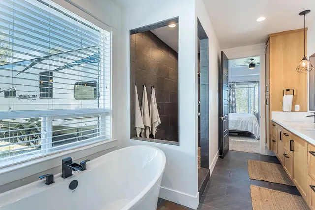 a en suite bathroom with a tub sink and mirror