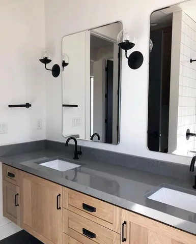 a bathroom with a granite countertop sink and a mirror