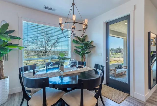 a dining room with furniture potted plants and wooden floor